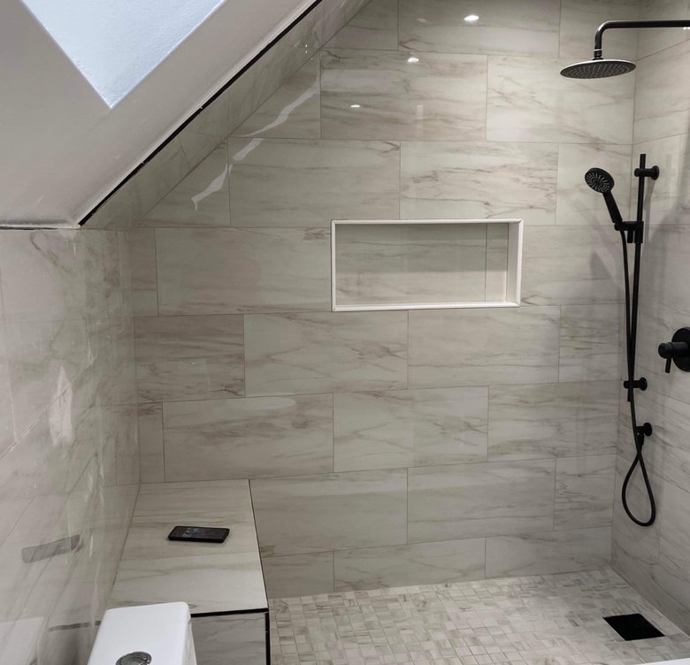 Custom walk-in shower with bench, niche and pebble tile floor